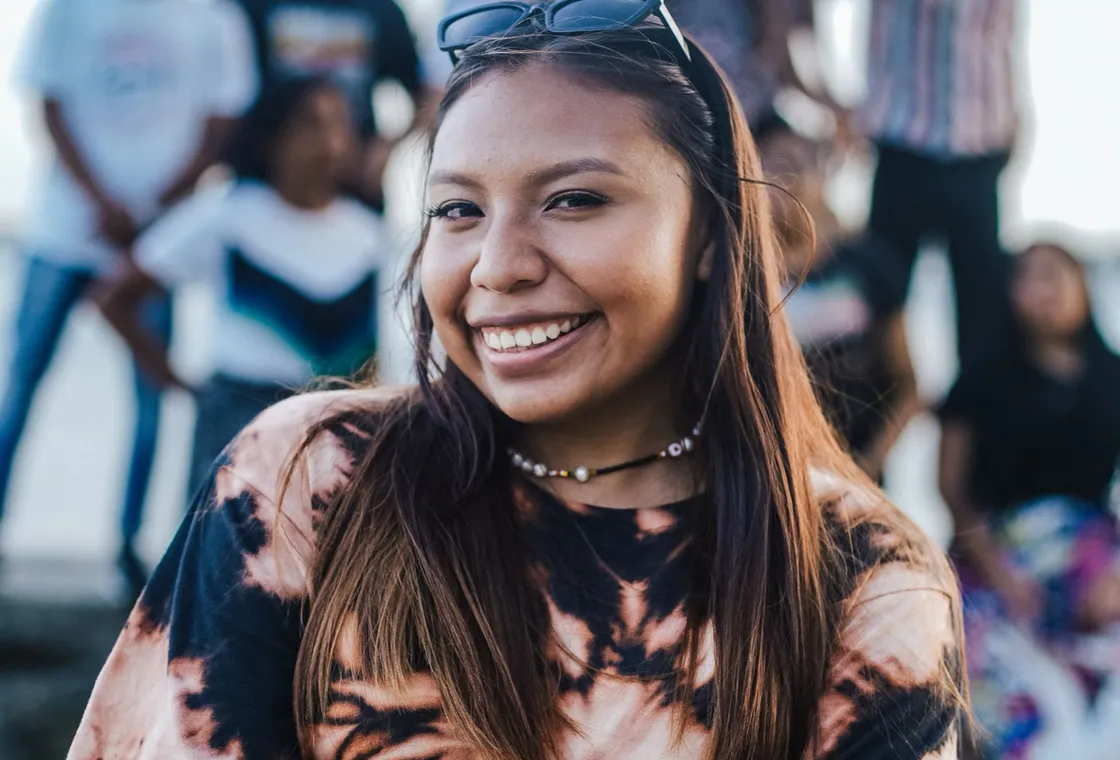 A smiling young woman standing with friends behind her